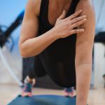 A woman in a black tank top is doing yoga